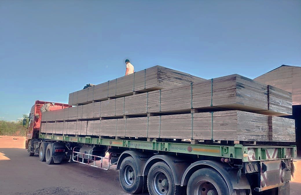 Semi-trailer loaded with strapped packs of engineered wood outside the factory